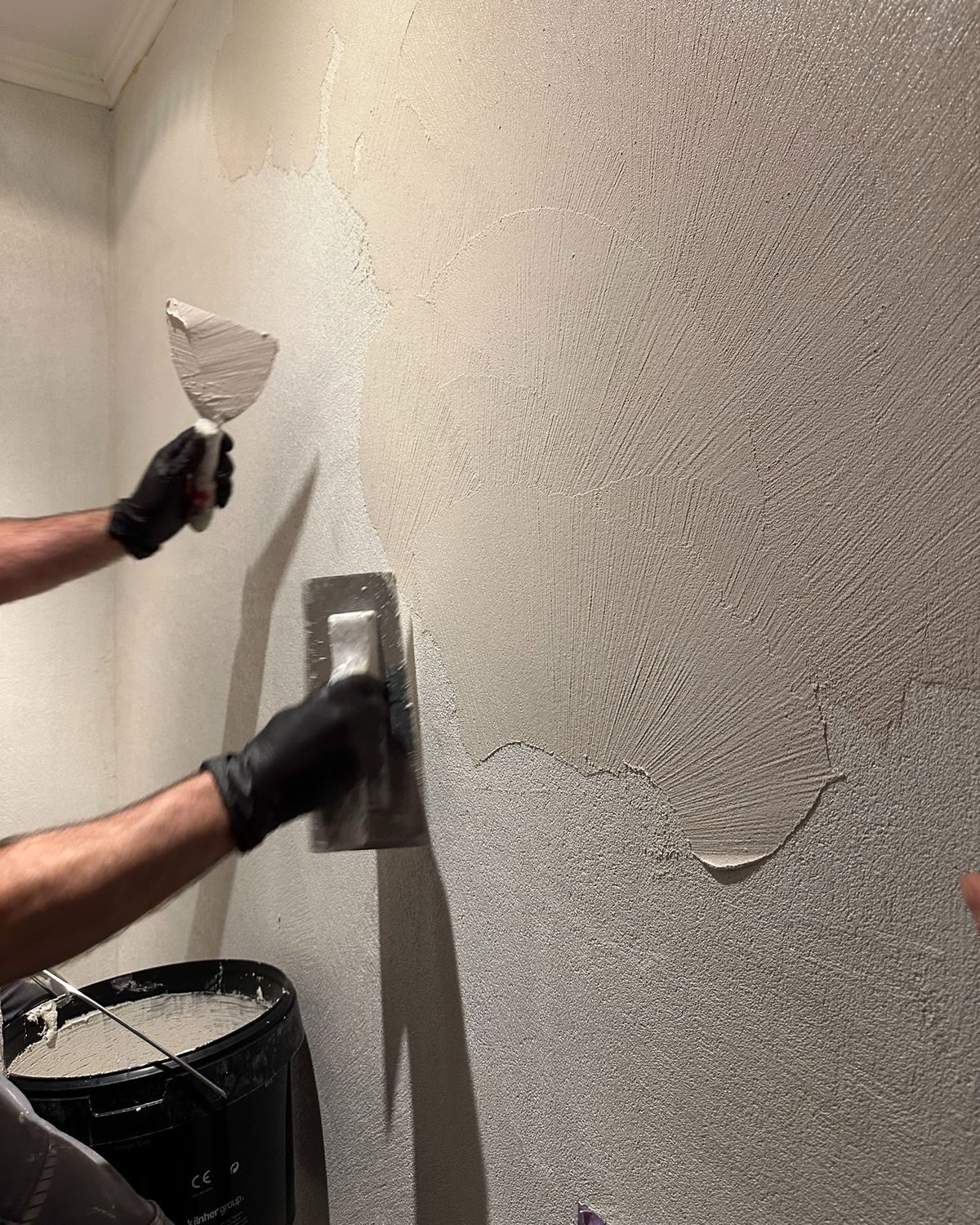 Limekote applicator hand-finishing a wall — small team of skilled artisans applying natural-material finishes on the Sunshine Coast